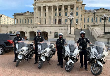 officers in helmets standing next to motorcycles